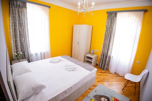a bedroom with a white bed and yellow walls at Lily's Guest House in Shahumyan