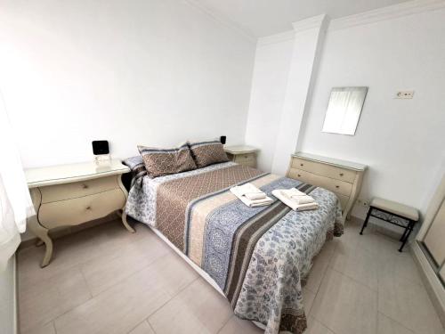 una piccola camera con 2 letti e una scrivania di Apartamento Lola2 a Nerja