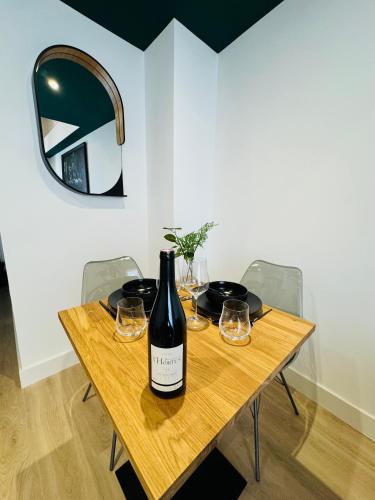 - une bouteille de vin sur une table en bois avec des verres dans l'établissement 307 Gare Saint Roch Montpellier, à Montpellier
