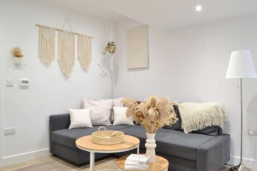 a living room with a couch and a table at New Flat near Luton Airport FREE PARKING in Luton