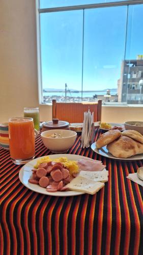 a table with a plate of breakfast food on it at kuntur inn hotel in Puno