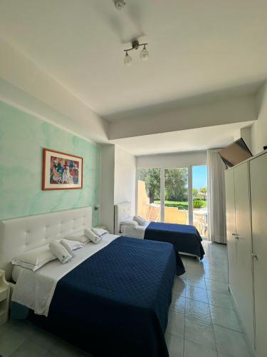 a bedroom with two beds and a balcony at Hotel America in Marina di Camerota