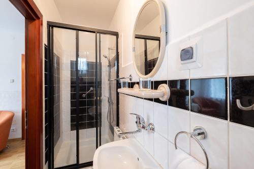 a bathroom with a sink and a mirror at Lawendowy Zakątek - przytulne pokoje i pyszne śniadania in Łeba