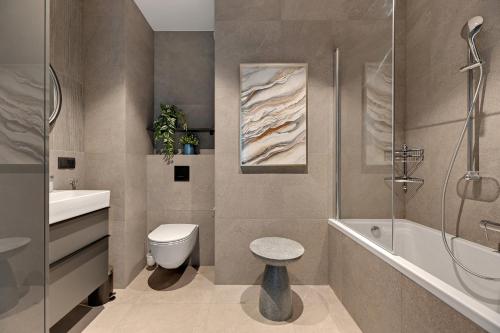 a bathroom with a toilet and a sink and a shower at Scala 3 by Grand Apartments in Gdańsk