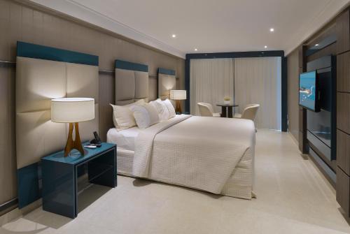 若昂佩索阿的住宿－坦巴烏盧克索諾德酒店，一间卧室配有一张大床和一台平面电视