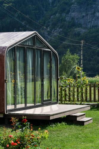 a small greenhouse in a garden with a fence at Guesthouse Prrockaj Theth in Theth