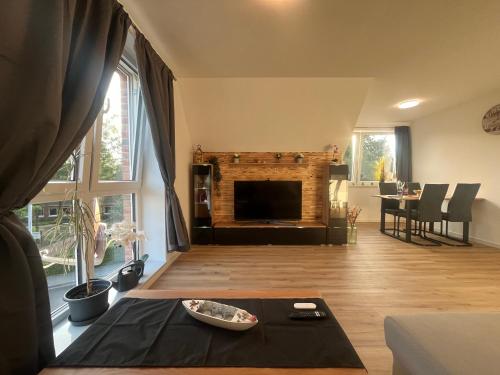 a living room with a fireplace and a table at FeWo Foorden Wohnglück 1 in Hesel