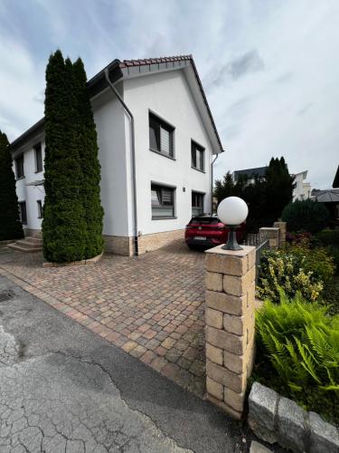 a white house with a brick driveway at Stilvolle Studiowohnung mit Sonnenterasse in Rheda-Wiedenbrück