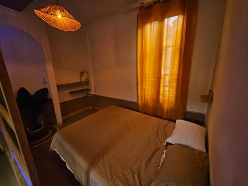 une petite pièce avec un lit et une fenêtre dans l'établissement Appartement cosy hyper centre, à Troyes