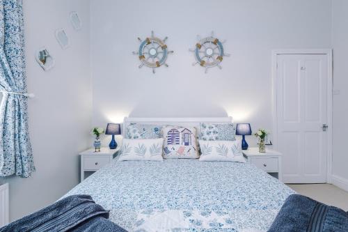 a bedroom with a bed with blue and white sheets and pillows at Trent House - Quality 3 Bedroom House Lytham in Brown Moss Side