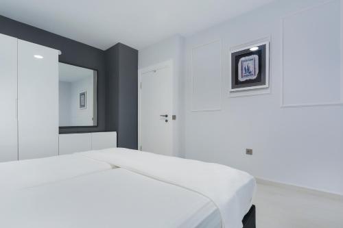 a bedroom with a white bed and a mirror at Twin Apart Hotel in Alanya