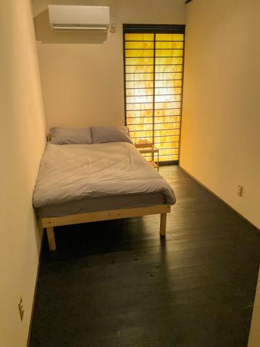 a bedroom with a bed in a room with a window at 奄美大島の宿 in Tatsugo