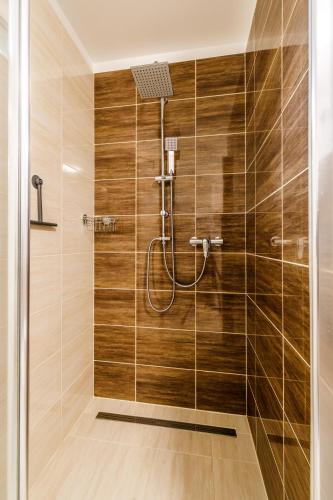a bathroom with a shower with wooden walls at Apartmán Simon - Horský Resort Buková Hora - Červená Voda in Červená Voda