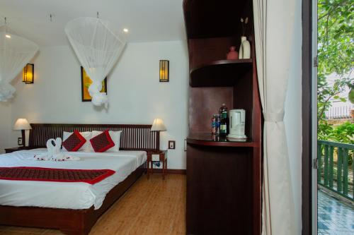 a bedroom with a bed and a balcony at Hoi An Garden Villas in Hoi An