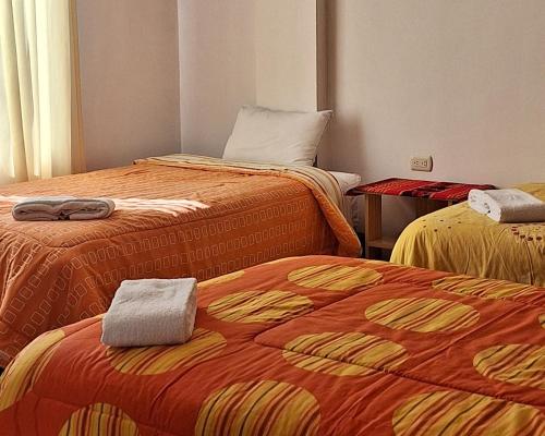a room with two beds with towels on them at kuntur inn hotel in Puno