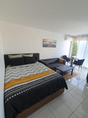 une chambre avec un lit et un salon dans l'établissement Studio terrasse vue mer, à Marseille