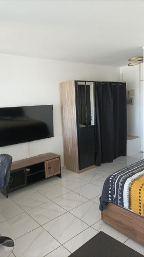 une chambre avec un lit et une télévision à écran plat dans l'établissement Studio terrasse vue mer, à Marseille