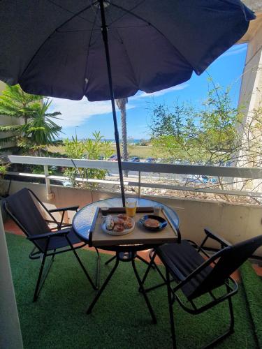 une table avec une assiette de nourriture et un parapluie dans l'établissement Studio terrasse vue mer, à Marseille