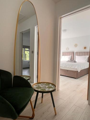 a room with a mirror and a chair and a bed at Mote Park View in Kent