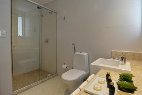 a bathroom with a toilet and a sink and a shower at Nord Luxxor Tambaú in João Pessoa