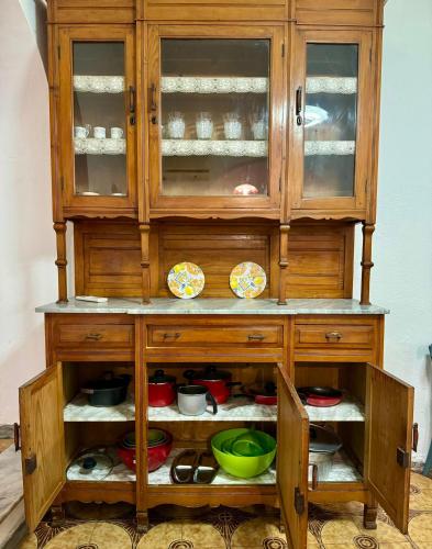 a wooden hutch with bowls and dishes in it at House Le Gallinelle in Assemini