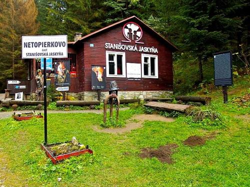 a small building with a sign in front of it at Bačova drevenica in Liptovský Ján