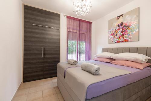 a bedroom with a large bed and a chandelier at M&B Green Oasis with pool and jacuzzi in Bibinje