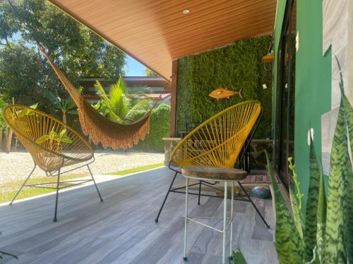 two chairs sitting on a porch with a plant at Villas Casa Paz in Cóbano