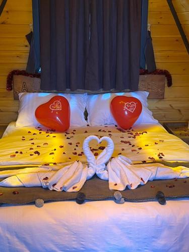 a bed with two swans and two hearts on it at AĞARAN Wooden Houses 2 in Cayeli