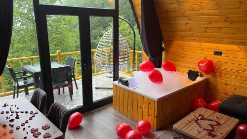 a room with a table with red balloons on it at AĞARAN Wooden Houses 2 in Cayeli