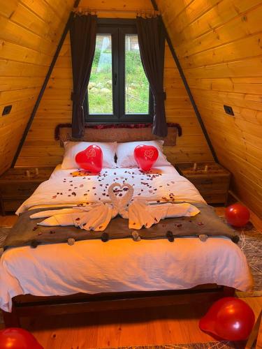 a bed in a wooden cabin with two hearts on it at AĞARAN Wooden Houses 2 in Cayeli