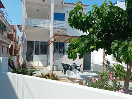 a balcony of a house with tables and chairs at Catherine's house in Artemida