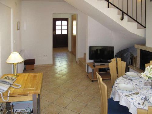 a living room with a table and a television at Holiday Home Yellowhouse in Kaštel