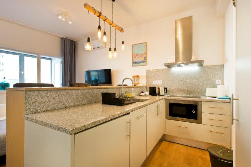 Una cocina con gabinetes blancos y encimera. en Casa Roberto - Studio Apartment, Lift, AC, Car Parking - extra, en Oporto