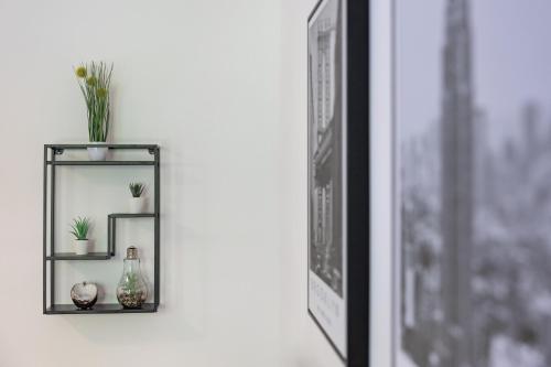 a shelf with plants and a mirror next to a window at SweetHome - Küche, Stellplatz, WLAN, Nähe S-Bahn in Munich