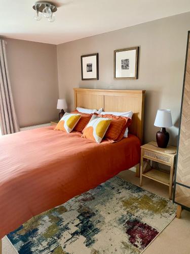 a bedroom with a large bed with orange sheets and pillows at 3 bed house near York centre with off road parking in York