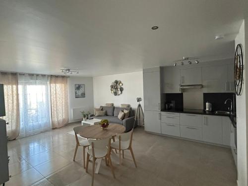 une cuisine et un salon avec une table et un canapé dans l'établissement Appartement calme, à Montfermeil