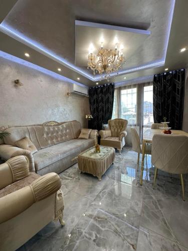 a living room with a couch and a chandelier at AR Luxury VIP Apartments Ravda in Ravda