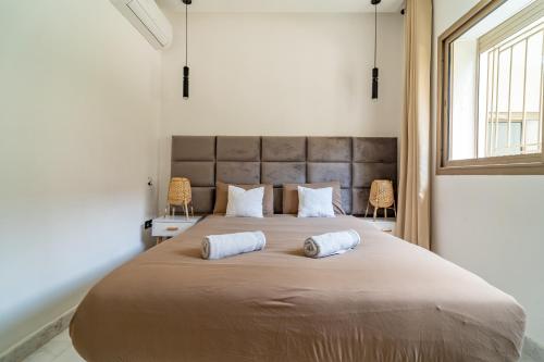 a bedroom with a large bed with two pillows on it at AeroHarmony in Nouaceur