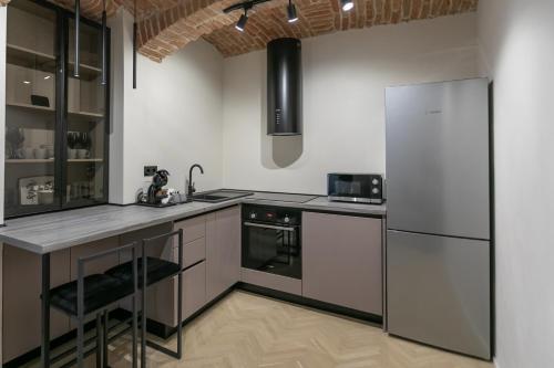 a kitchen with a counter and a refrigerator at Biagio Boutique Studio - in Old Town - Ultra Central in Braşov