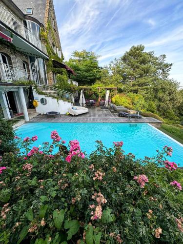 - une piscine en face d'une maison fleurie dans l'établissement LA MAISON DE ROBINSON, au Plessis-Robinson