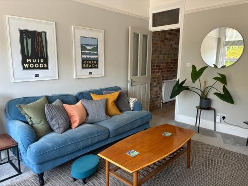 a living room with a blue couch and a table at Charming Edwardian maisonette in trendy location, minutes from restaurants and pubs in Ashley Cross, Poole in Poole