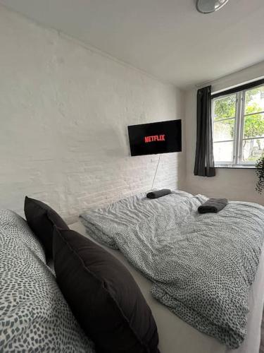 a bedroom with two beds and a clock on the wall at Moderne lejlighed ved Flensborg havn in Flensburg