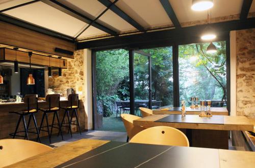 ル・プレシ・ロバンソンにあるLA MAISON DE ROBINSONのテーブルと椅子と大きな窓のあるレストラン