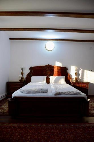 a bedroom with a bed with a wooden headboard at Casa David 13D in Nimăeşti
