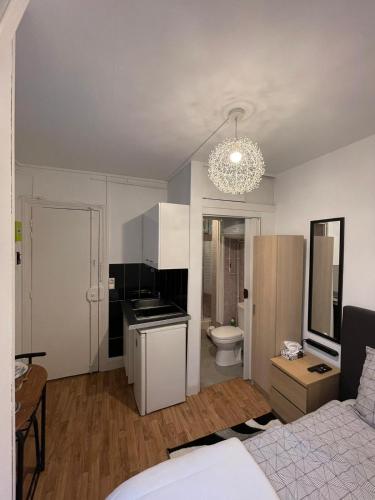 une chambre avec un lit et une cuisine avec un lustre dans l'établissement Dame de fer apartment, à Paris