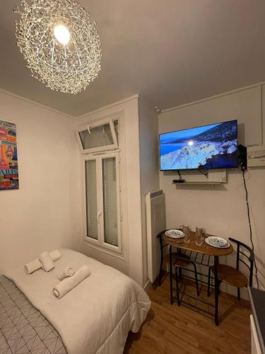 une chambre avec un lit, une table et une télévision dans l'établissement Dame de fer apartment, à Paris