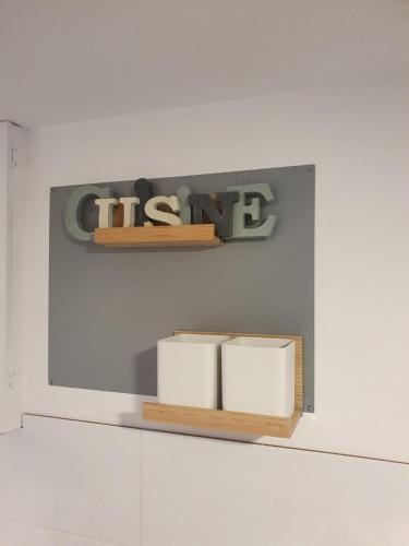 a shelf with two books and a sign on a wall at Joli studio décoré proximité cure centre ville in Rochefort
