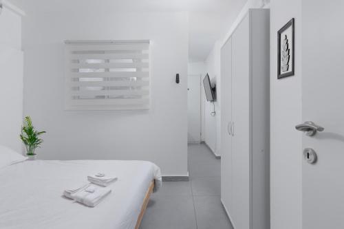 a white room with a bed and a bathroom at השיטה 1 in Eilat