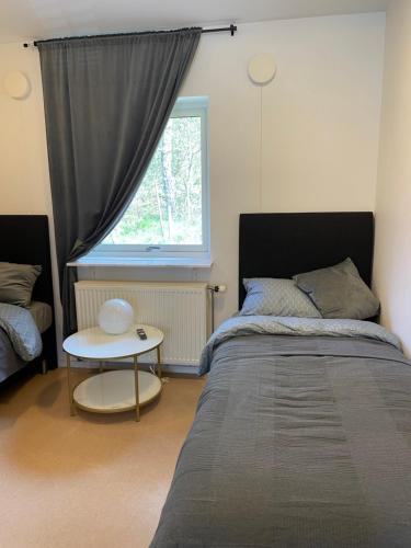 a bedroom with a bed and a table and a window at långstorp in Höör